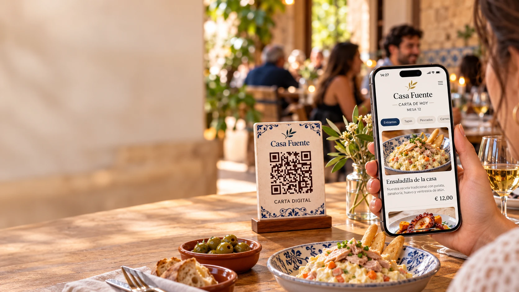 Clientes en la mesa de un local de hostelería viendo la carta digital de Casa Fuente en el móvil, con el código QR de la mesa